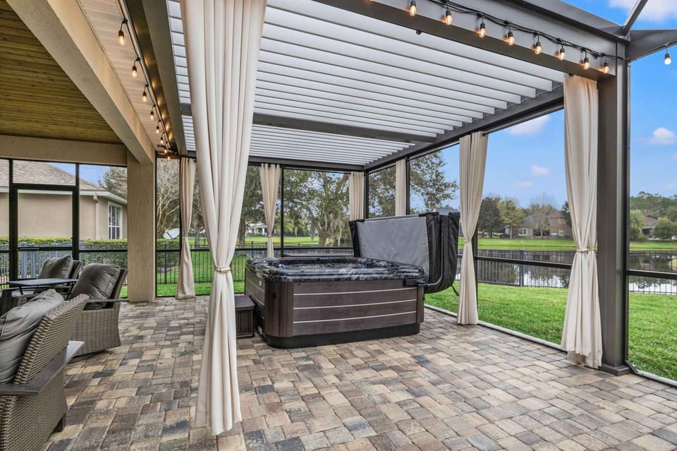 Lighting and Hanging Fabric Curtains Surrounding Jacuzzi Outdoor Oasis - Impact Enclosures - Outdoor Enclosures Jacksonville