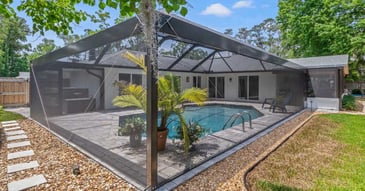 Screen enclosure over a pool with landscaping in Jacksonville, FL by Impact Enclosures
