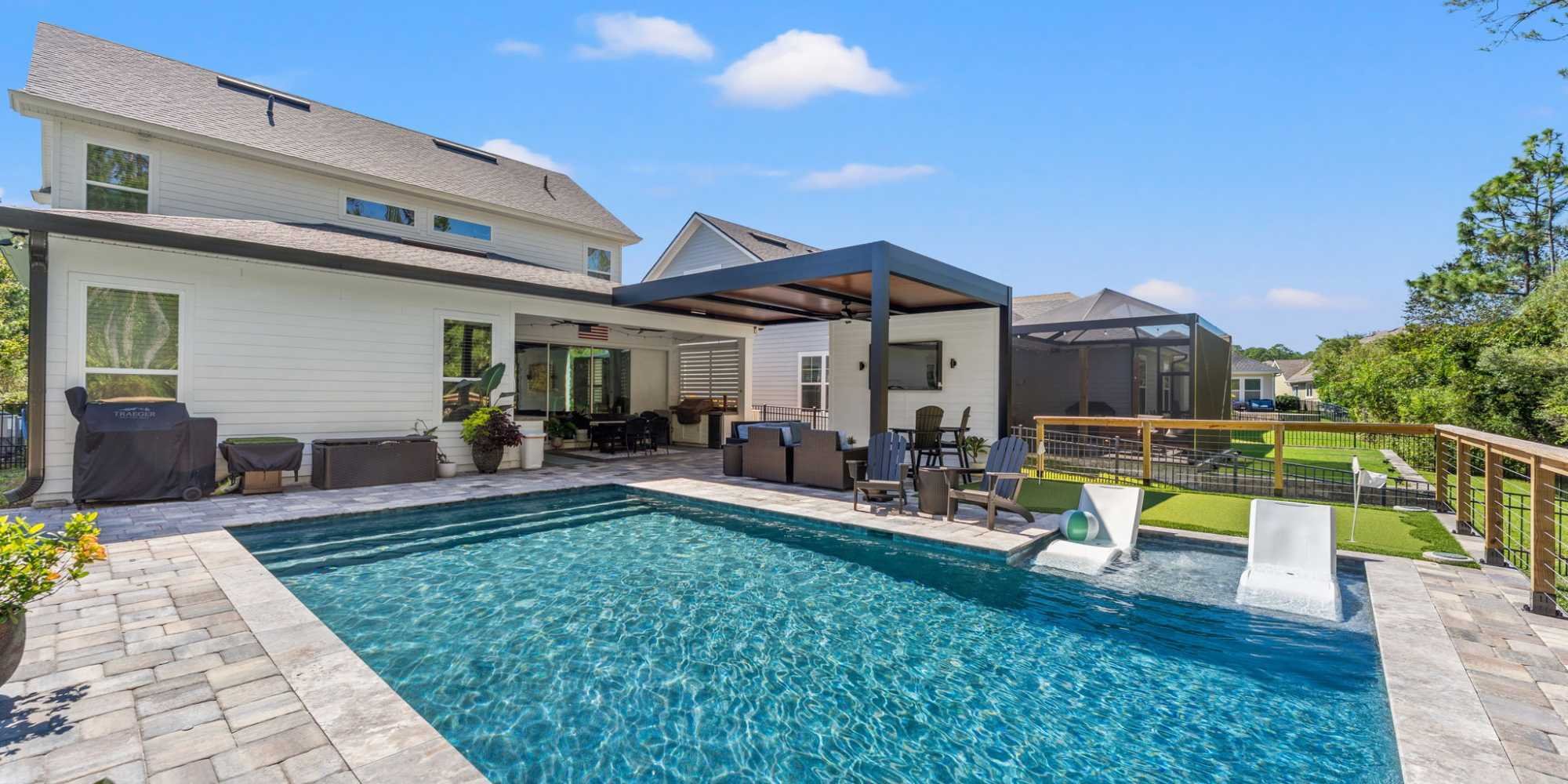 Image of outdoor living space with pool, covered patio, and modern pergola in Jacksonville, FL by Impact Enclosures