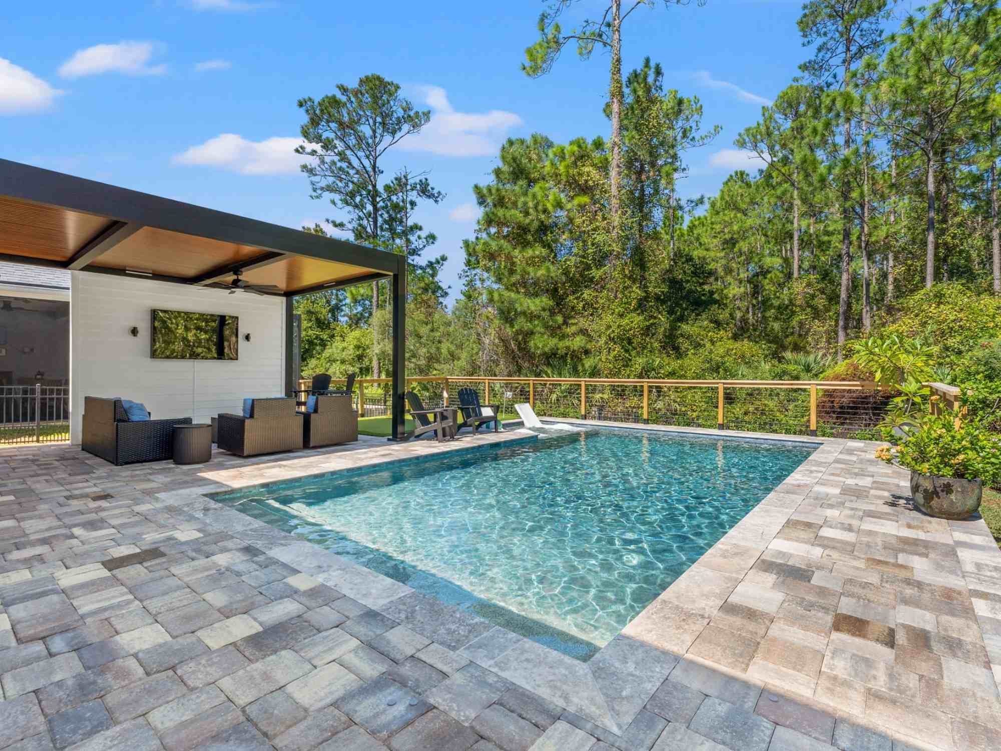 Photo of covered outdoor patio with wood slat ceiling beside pool in Jacksonville, FL by Impact Enclosures Photo of covered outdoor patio with wood slat ceiling beside pool in Jacksonville, FL by Impact Enclosures