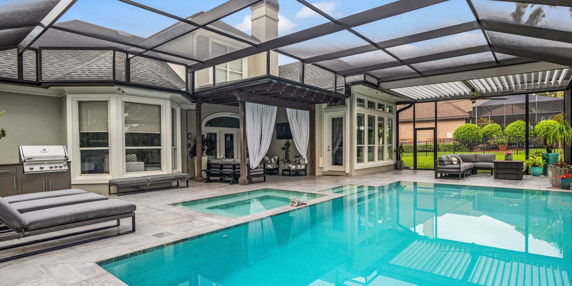 Outdoor patio with screen enclosure over a pool and hot tub - Impact Enclosures - Jacksonville, FL