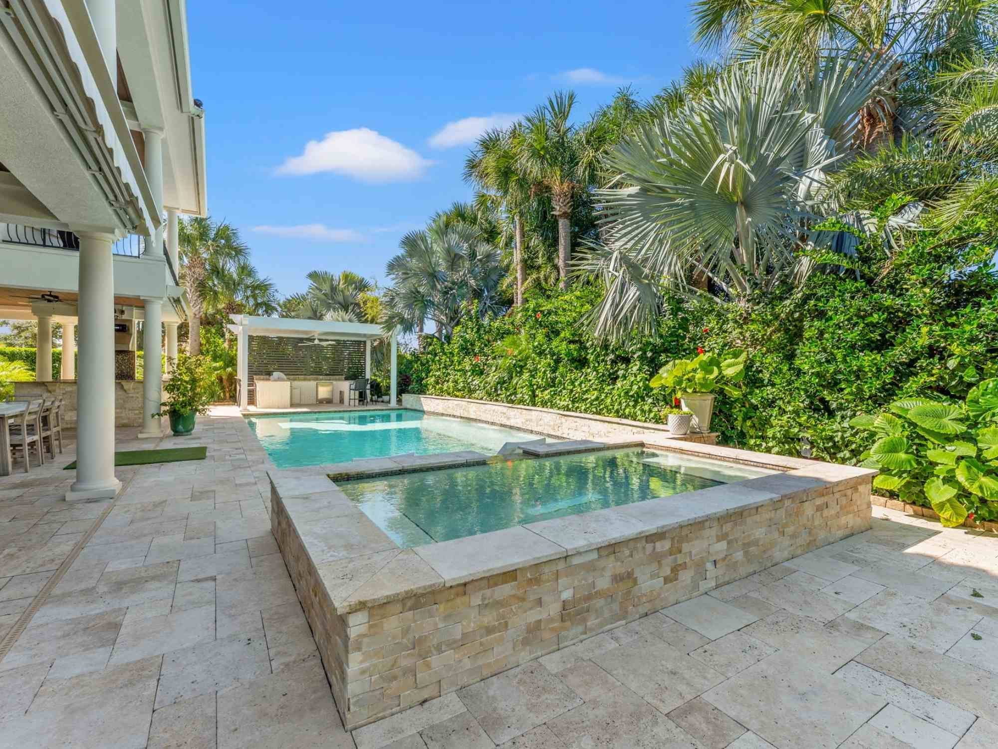 Image of a hot tub, swimming pool, pergola, and outdoor kitchen in Ponte Vedra Beach by Impact Enclosures Image of a hot tub, swimming pool, pergola, and outdoor kitchen in Ponte Vedra Beach by Impact Enclosures