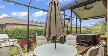 Jacksonville, FL enclosed patio upgrade by Impact Enclosures with modern grill, dining set, and hot tub