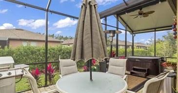 Jacksonville, FL enclosed patio upgrade by Impact Enclosures with modern grill, dining set, and hot tub