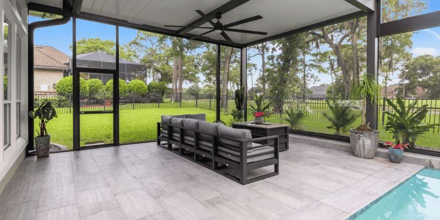 Enclosed screen patio with a pool and lounge area - Impact Enclosures - Jacksonville, FL