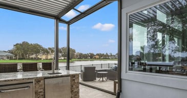 Image of a patio with outdoor kitchen and motorized screen in Jacksonville, Fl by Impact Enclosures