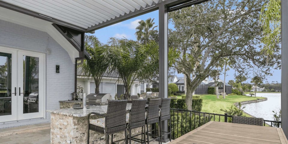 Image of an outdoor patio with kitchen and pergola by Impact Enclosures in Jacksonville, FL
