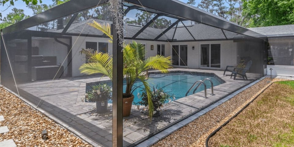 Screened pool enclosure by Impact Enclosures in Jacksonville, FL with paver deck