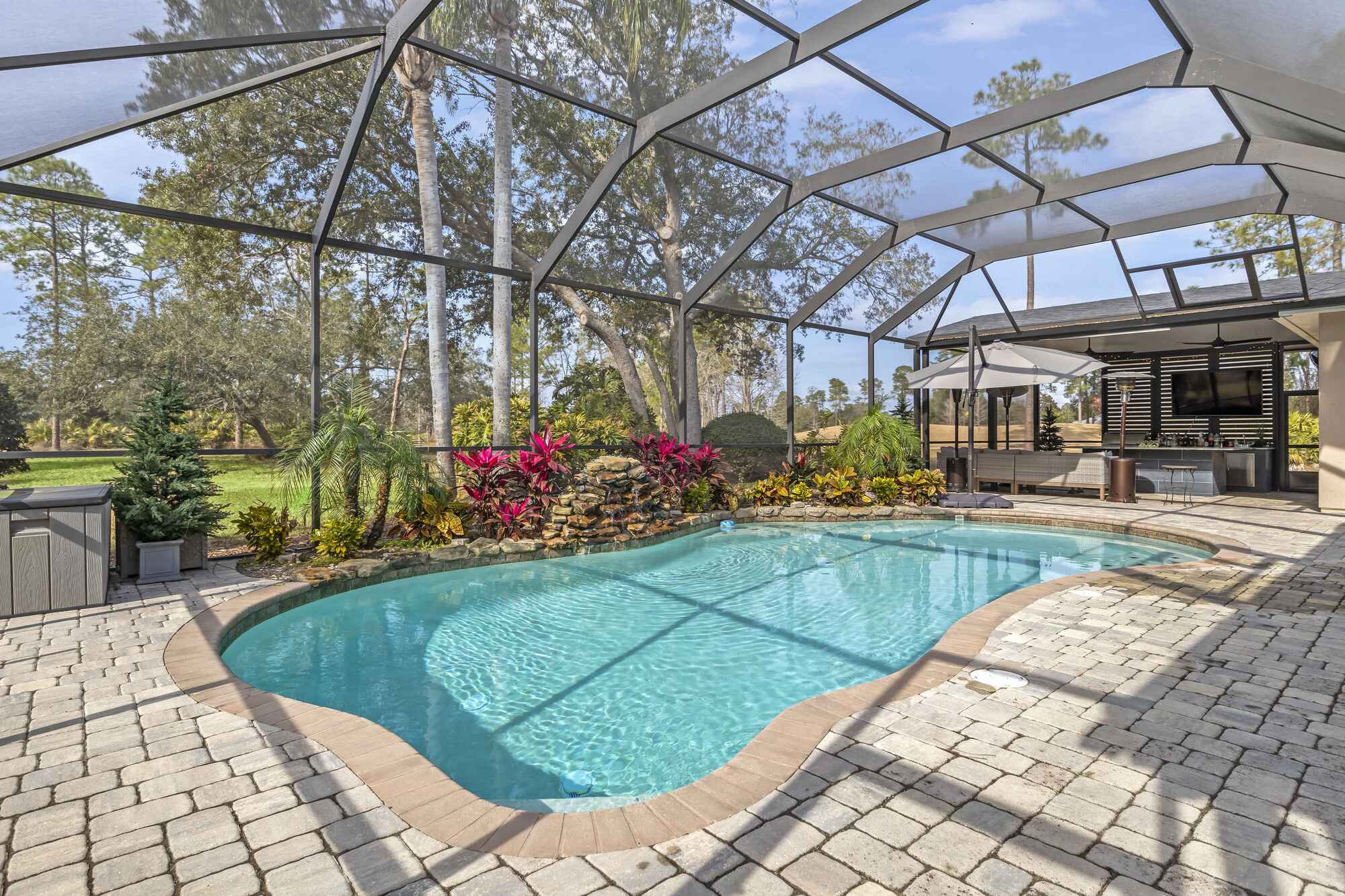 Stone Patio Pool Enclosure with Waterfall and Landscaping