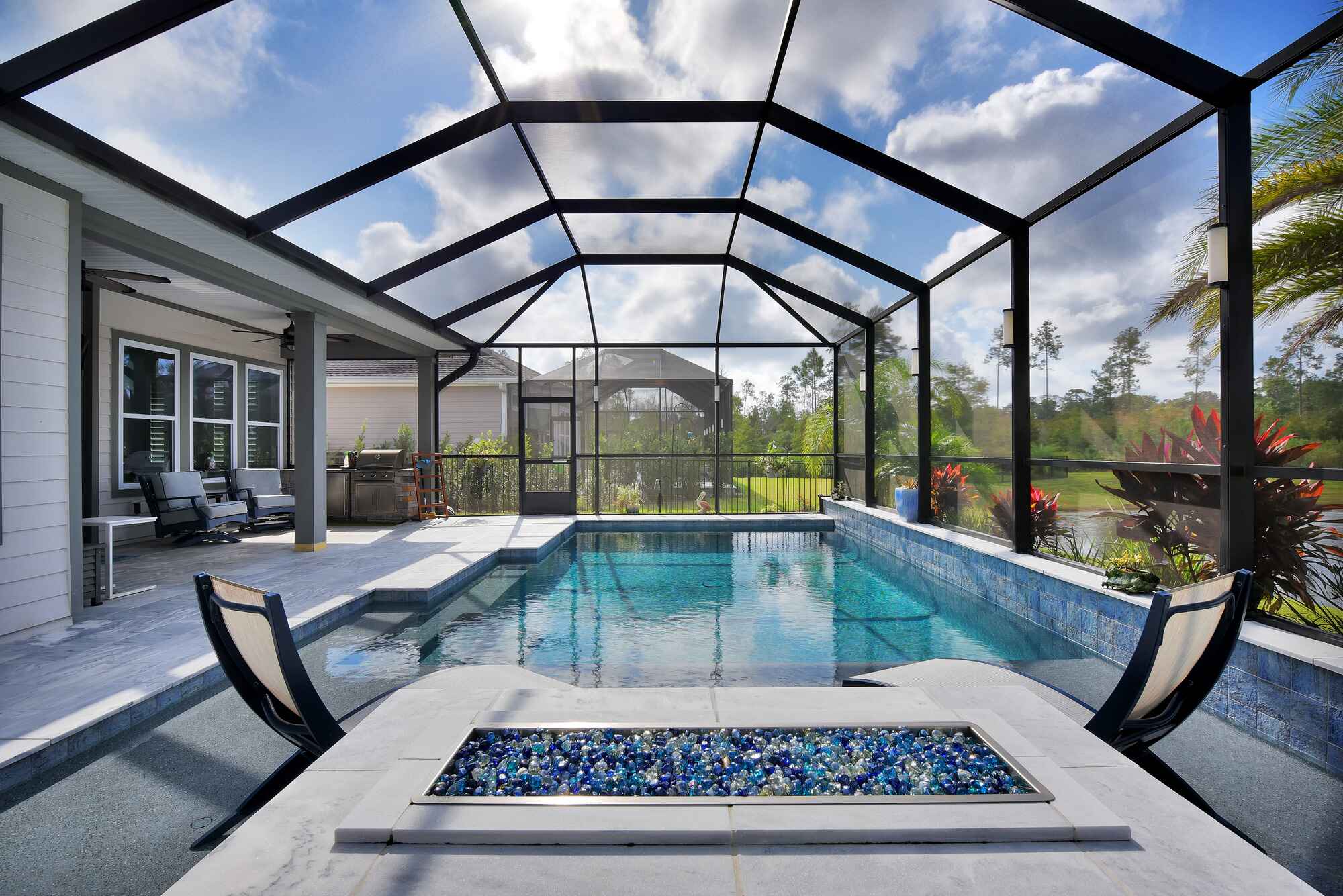 Black and White Pool Screen Enclosure with Custom Firepit and Entertainment Space